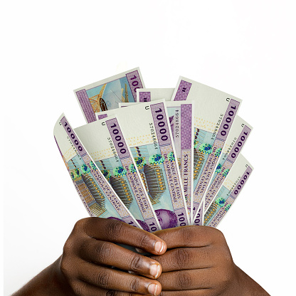 Black hands holding 3D rendered 10000 Central African CFA franc notes. closeup of Hands holding Nigerian currency notes