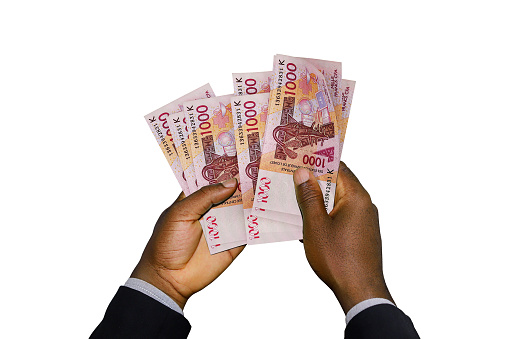 Black Hands in suit holding 3D rendered CFA Franc notes
